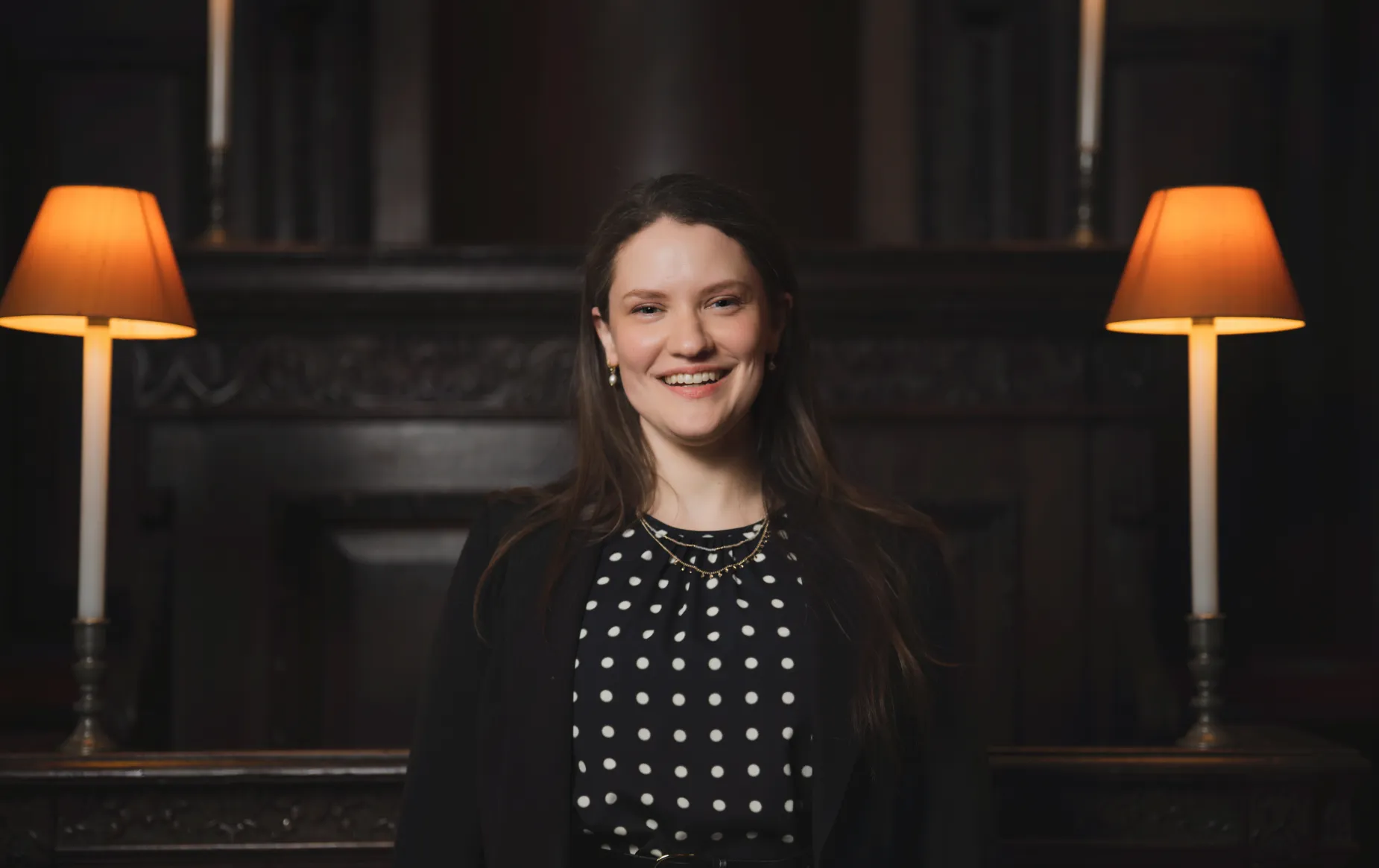 Hilary Punnett sits in the Choir of St Paul's cathedral, a dark wooden stall between two lanterns.