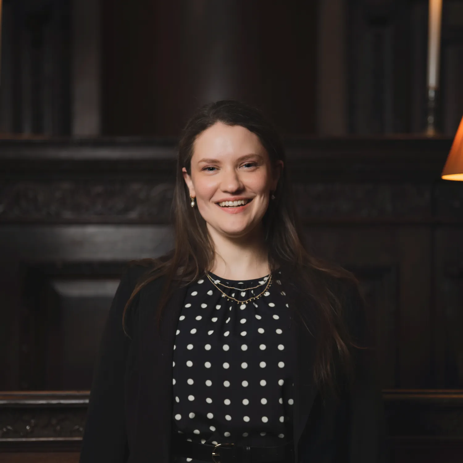 Hilary Punnett sits in the Choir of St Paul's cathedral, a dark wooden stall between two lanterns.