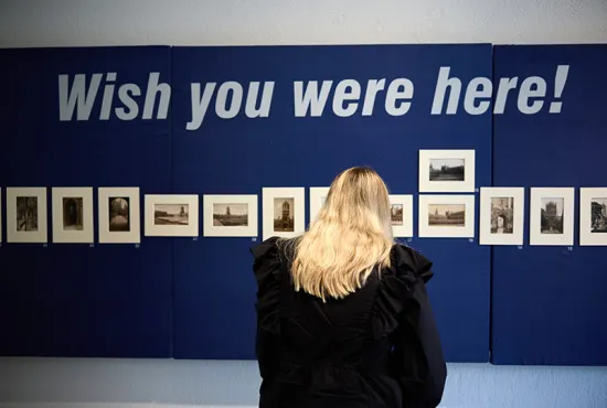 Woman viewing the 'Wish you were here!' exhibition