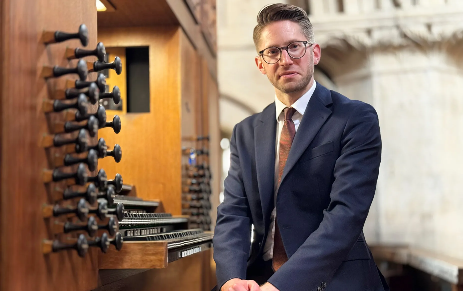 Peter Holder, new organist of Christ Church, sits at the wooden console of the Rieger Organ.
