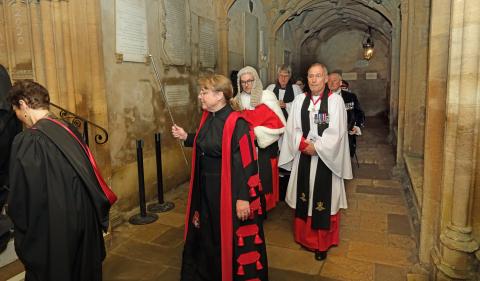 The legal service procession enters the cathedral, led by the verger.