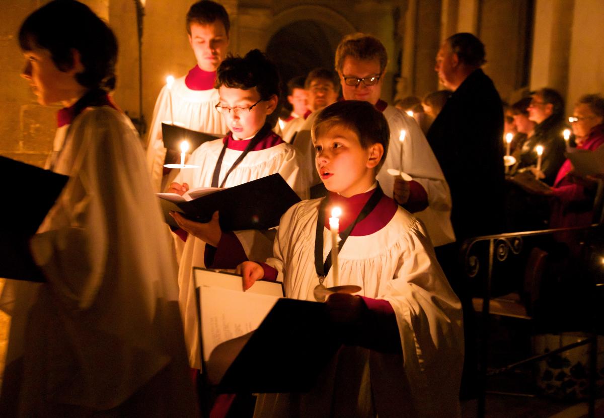 Choristers hold candles while in procession at a carol service in the cathedral