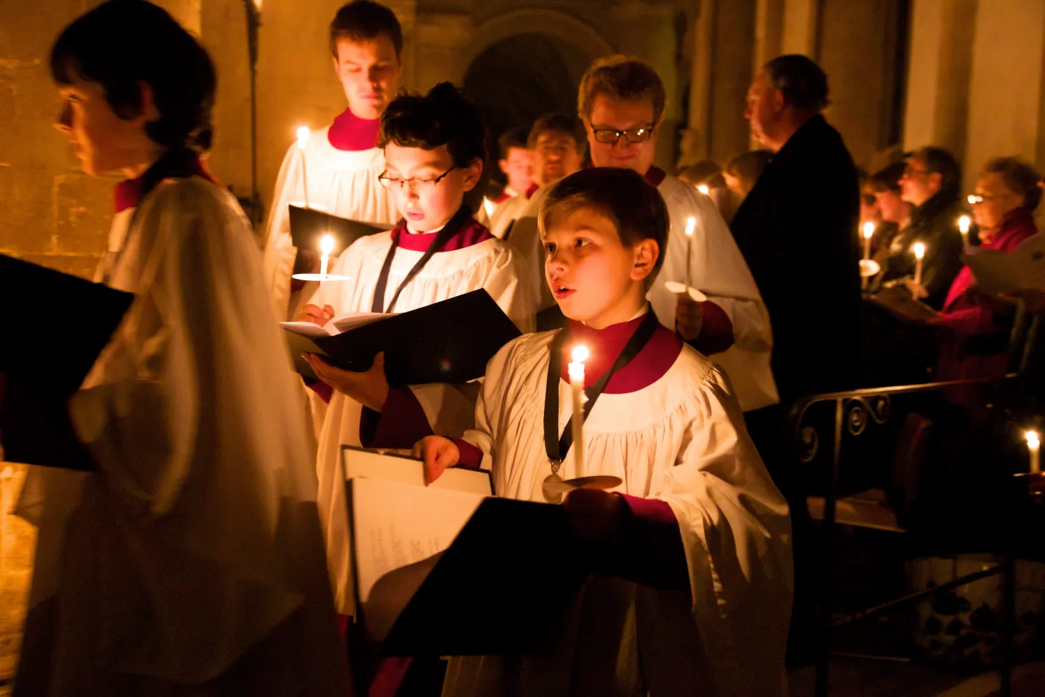 Choristers hold candles while in procession at a carol service in the cathedral